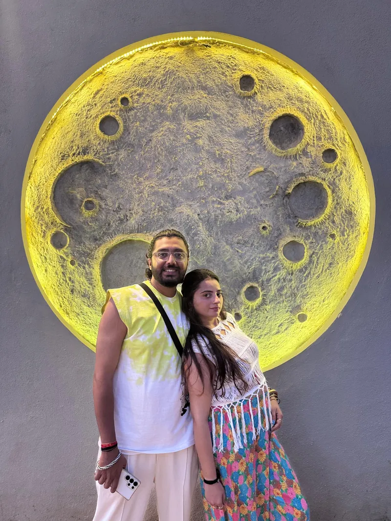 Indian couple at a moon art wall in Sri Lanka